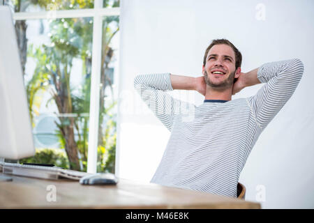 Entspannen Sie sich auf seinem Schreibtischstuhl gut aussehend Geschäftsmann Stockfoto