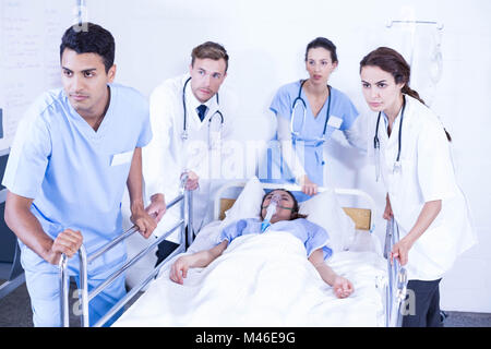 Betroffenen Ärzte stehen in der Nähe von Patienten auf Bett Stockfoto