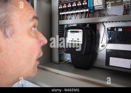 Nahaufnahme einer schockiert Mann an Stromzähler Suche Stockfoto