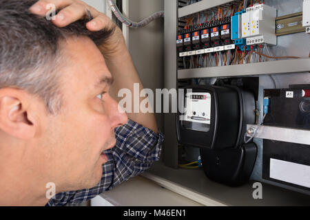 Nahaufnahme einer schockiert Mann an Stromzähler Suche Stockfoto