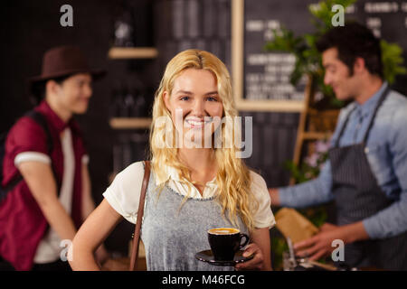 Porträt von lächelnden hübschen Kunden halten Tasse Kaffee Stockfoto