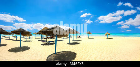 Panoramablick auf die Landschaft mit Sonnenschirmen auf dem sandigen Strand an der sonnigen Tag. Nabeul, Tunesien, Nordafrika Stockfoto