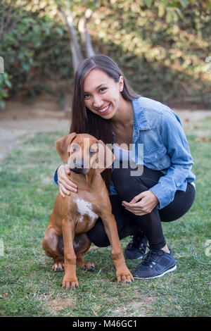 Junge ethnische Frau und ihr Hund Stockfoto