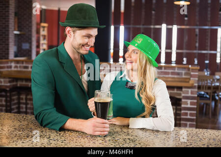 Mann und Frau einander haltend Biere betrachtend Stockfoto