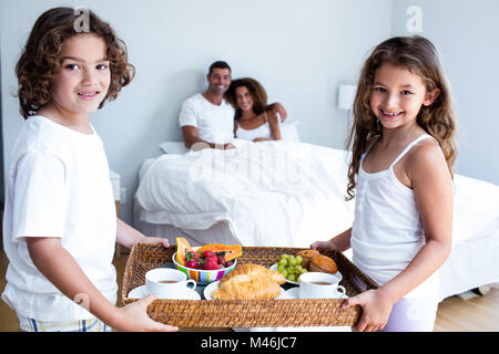 Porträt von Tochter und Sohn mit Frühstückstablett für Eltern Stockfoto