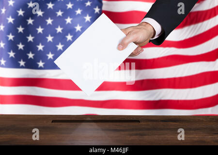 Nahaufnahme der Kaufmann Stimmzettel in Feld einfügen vor der amerikanischen Flagge Stockfoto