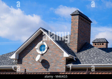 Asphalt Kies. Dekorative bitumen Schindeln auf dem Dach eines Brick House Stockfoto