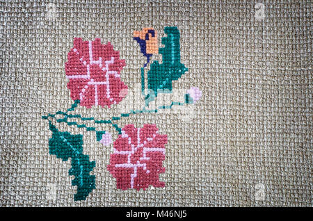 Handarbeit: bestickte Zick-Zack-Muster von schönen Blumen auf Leinwand. Handgefertigt. Stockfoto