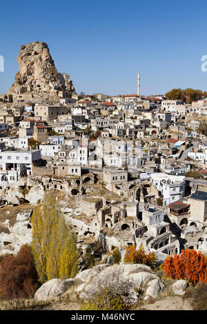 Blick über die Felsen und dweliings mit hohen Felsen als Burg Ortahisar, in Kappadokien, Türkei bekannt. Stockfoto