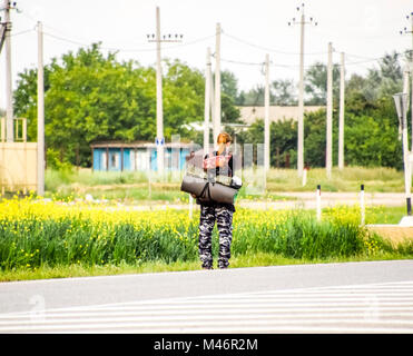 Krasnodar, Russland - 1. Juni 2017: Per Anhalter. Mädchen Auto - Stopper. Das Mädchen mit dem Rucksack hält das Auto. Abstimmung über den Track. Stockfoto