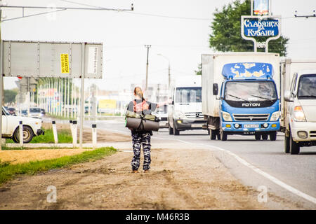 Krasnodar, Russland - 1. Juni 2017: Per Anhalter. Mädchen Auto - Stopper. Das Mädchen mit dem Rucksack hält das Auto. Abstimmung über den Track. Stockfoto