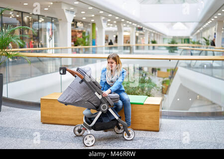 Junge lächelnde Frau mit ihrem Baby sprechen Stockfoto