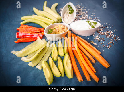 Frisches Gemüse Snacks mit Dips auf blauem Hintergrund Stockfoto