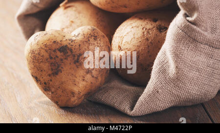 Sack voller Bio-Kartoffeln auf Eiche Holztisch Stockfoto