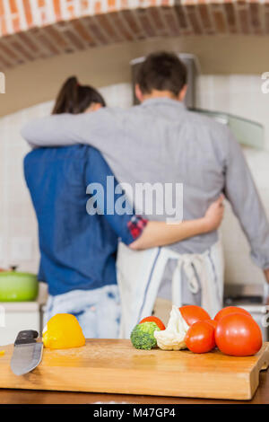 Gemüse auf schneiden Board und paar umarmt Stockfoto