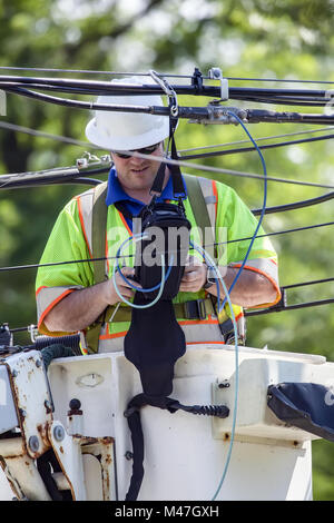 Power line Techniker arbeiten aus einer Cherry Picker. Stockfoto