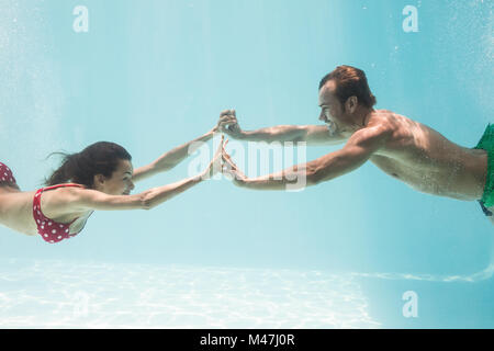 Paar Hand in Hand beim Schwimmen unter Wasser Stockfoto