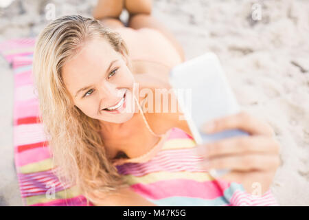 Hübsche Frau im Bikini unter einem Selfie am Strand Stockfoto