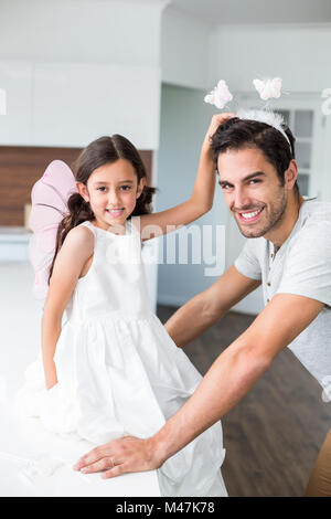 Porträt der lächelnden Vater mit Schmetterling Stirnband und Tochter Stockfoto