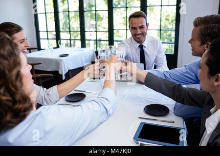 Gruppe von Geschäftsleuten Toasten Glas Wasser im restaurant Stockfoto