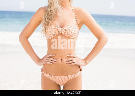Mittleren Bereich der Frau im Bikini stehen am Strand Stockfoto
