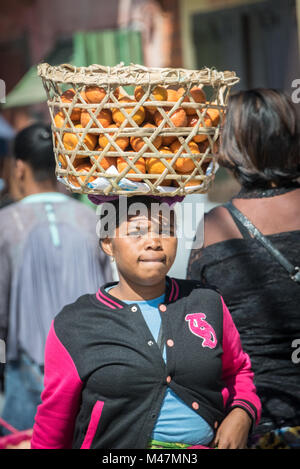 Dame mit Orangen in einem Korb auf dem Kopf, Fianarantosa, Madagaskar Stockfoto