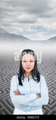 Das zusammengesetzte Bild der Frau mit verschränkten Armen an Kamera suchen Stockfoto
