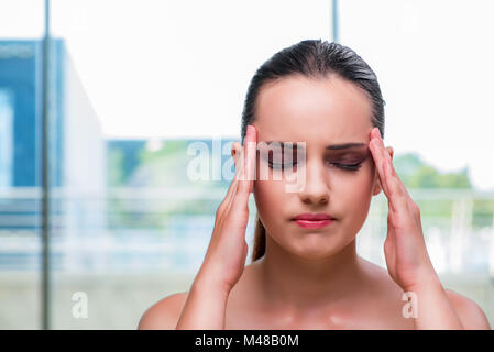 Junge Frau hält ihre Tempel mit Kopfschmerzen Stockfoto