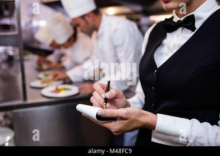 Nahaufnahme der Kellnerin mit Notizblock in Großküchen Stockfoto