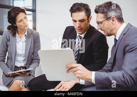 Business-Profis halten Dokumente in Zwischenablage Stockfoto