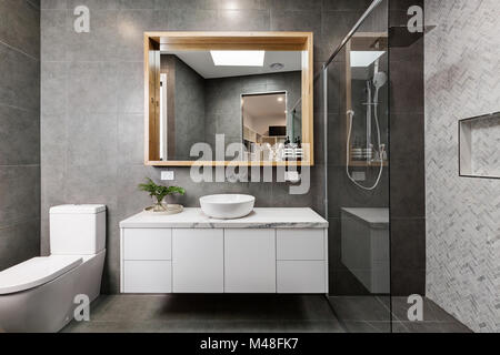Modernes, graues Designer Badezimmer mit Fischgrätenmuster dusche Fliesen Stockfoto