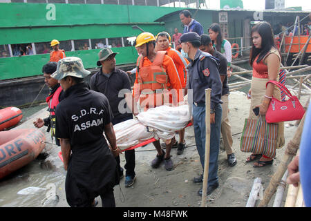 Guwahati, Indien. 14 Feb, 2018. NDRF (National Disaster Response Force) und SDRF (Staatliche Disaster Response Fund) Personal nahm eine verletzte ältere Frau für die Behandlung während der Shiva Puja zu Umananda Devaloi, ein Shiva Tempel auf der Pfaueninsel in der Mitte des Flusses Brahmaputra gelegen. Quelle: David Talukdar/Pacific Press/Alamy leben Nachrichten Stockfoto