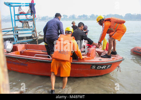 Guwahati, Indien. 14 Feb, 2018. NDRF (National Disaster Response Force) und SDRF (Staatliche Disaster Response Fund) Personal nahm eine verletzte ältere Frau für die Behandlung während der Shiva Puja zu Umananda Devaloi, ein Shiva Tempel auf der Pfaueninsel in der Mitte des Flusses Brahmaputra gelegen. Quelle: David Talukdar/Pacific Press/Alamy leben Nachrichten Stockfoto