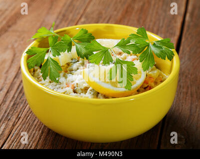 Schüssel Salat mit Zitrone und Petersilie auf rustikalen Tisch Stockfoto