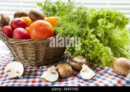 Frisches Gemüse mit Wassertropfen im Korb abgedeckt Stockfoto