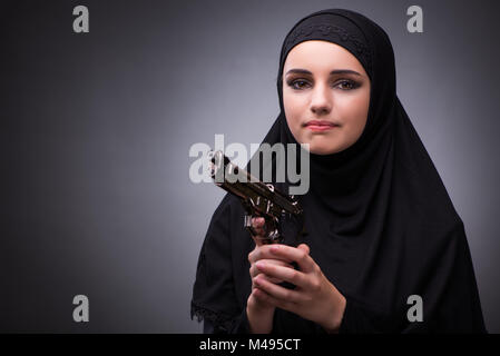 Die muslimische Frau im schwarzen Kleid vor einem dunklen Hintergrund Stockfoto