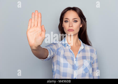 Verbot Symbol. Closeup Portrait von Jungen, Ernst, Pretty, charmante Mädchen in kariertem Hemd, stop Geste mit der Handfläche ihre Hand auf grau Bac Stockfoto