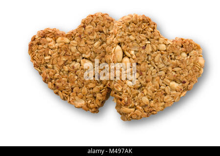 Zwei selbstgebackene herzförmige Erdnuss und Hafer flapjack Kekse für Valentines Tag auf weißem Hintergrund. Stockfoto