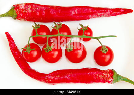 Cherry Tomaten und Hülsen der chili peppers isoliert Stockfoto