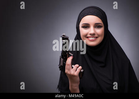 Die muslimische Frau im schwarzen Kleid vor einem dunklen Hintergrund Stockfoto