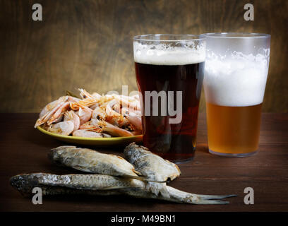 zwei Gläser Bier mit getrockneten Fischen und Krebsen Stockfoto