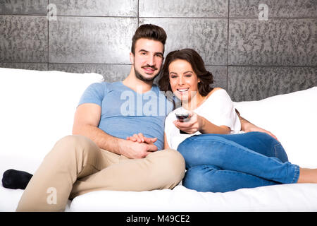 Junges Paar einen lustigen Film gemeinsam auf dem Sofa Stockfoto