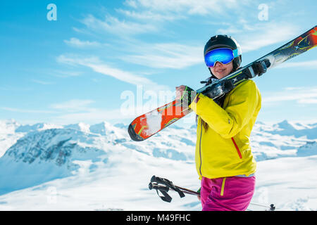 Bild von Mädchen mit Helm, Maske mit Skier auf die Schulter Stockfoto