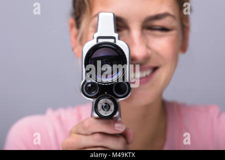 Nahaufnahme einer Lächelnden jungen Frau durch die Linse der Kamera Stockfoto