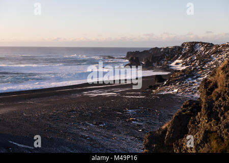 Atlantik Wellen gegen die verschneite schwarzen Sand-/Kiesel Djúpalónssandur Strand auf der Halbinsel Snaefellsnes im Westen von Island im Winter Stockfoto