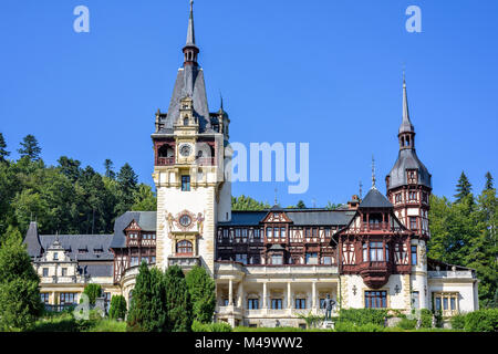 Tageslicht Vorderansicht mit verzierten Fassade von Schloss Peles mit Turm und der strahlend blaue Himmel mit Wolken. Rumänische Könige Sommerresidenz in Karpaten Mou Stockfoto