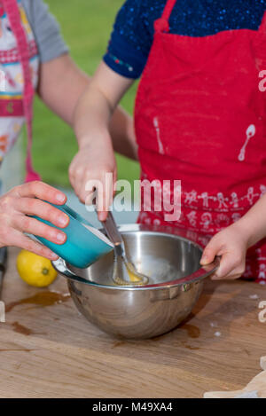 Mutter und Tochter einen Kuchen in einer Küche Stockfoto