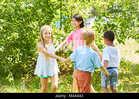 Kinder aus der internationalen Kindergarten eine kreisförmige Tanzen machen Stockfoto