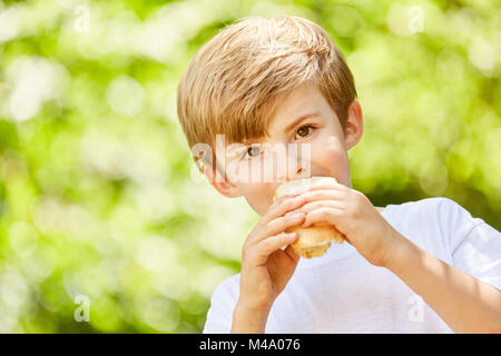 Hungrige Junge als Student isst ein Baguette als Pause essen in der Pause Stockfoto