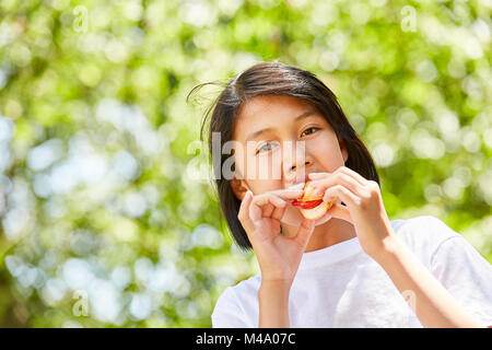 Asiatische Mädchen ist Essen ein Baguette als Pause Brot oder eine Party Snack Stockfoto